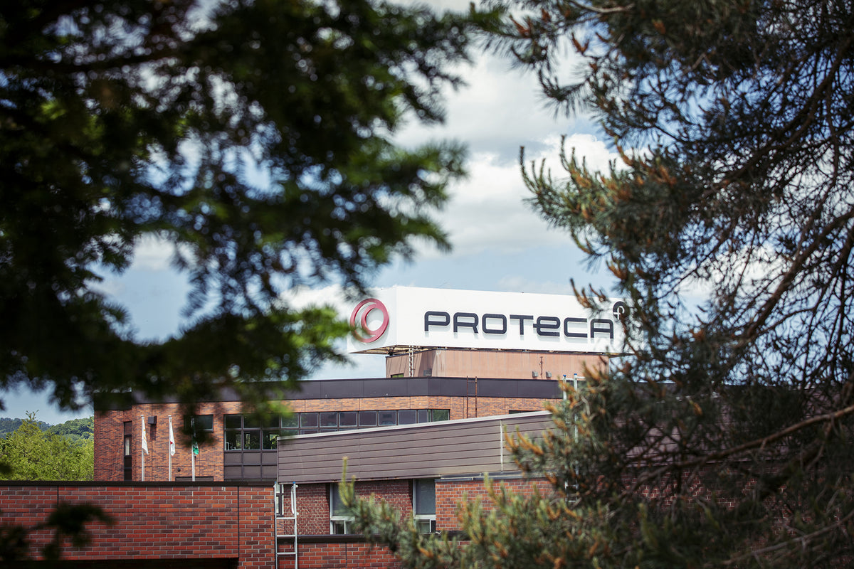 PROTECA factory building viewed through surrounding trees in Hokkaido