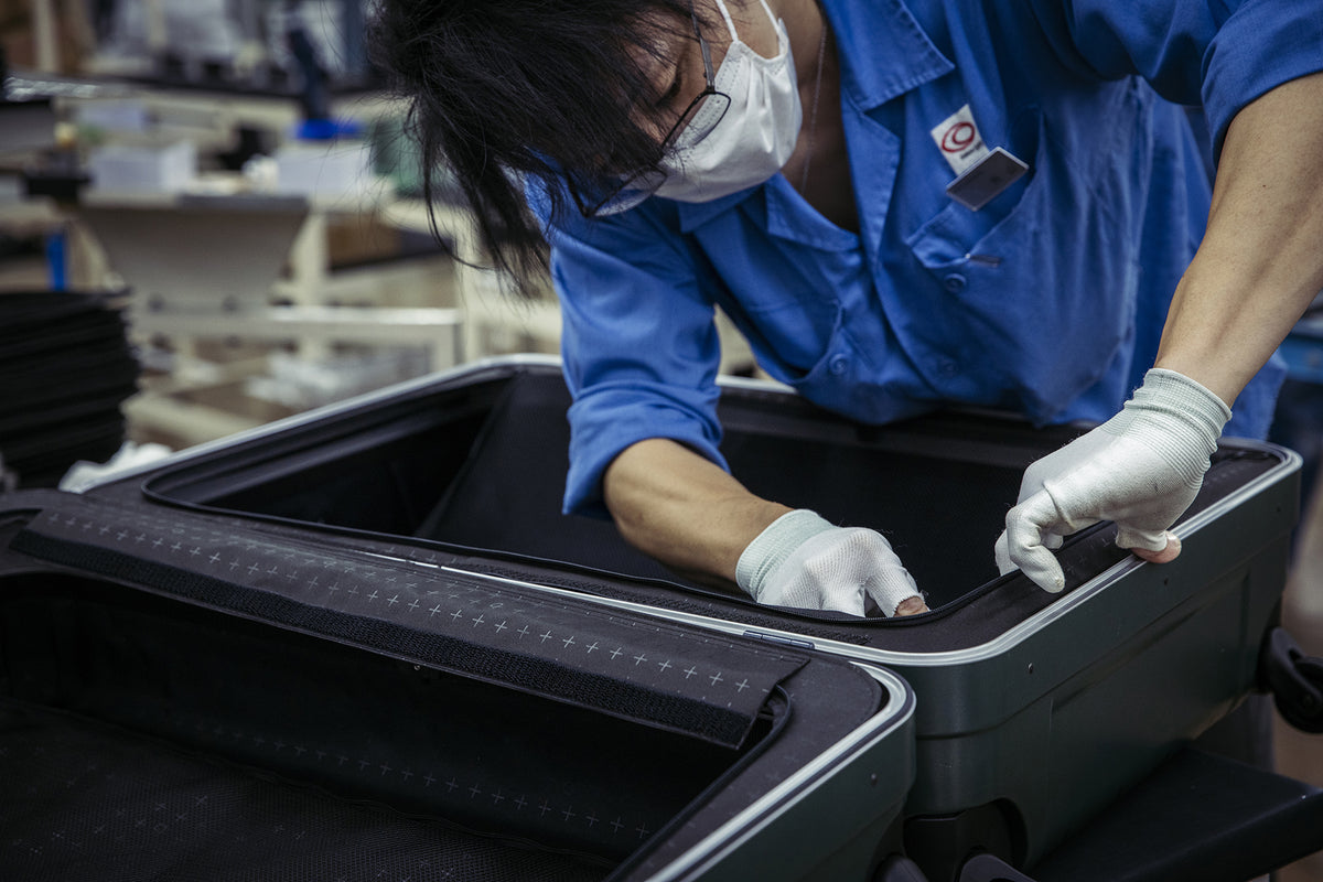 Hand-finishing the interior of a PROTECA suitcase during assembly