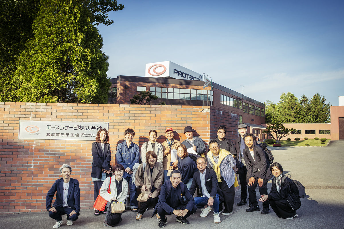 Team photo in front of PROTECA Hokkaido Akabira Factory building in Japan