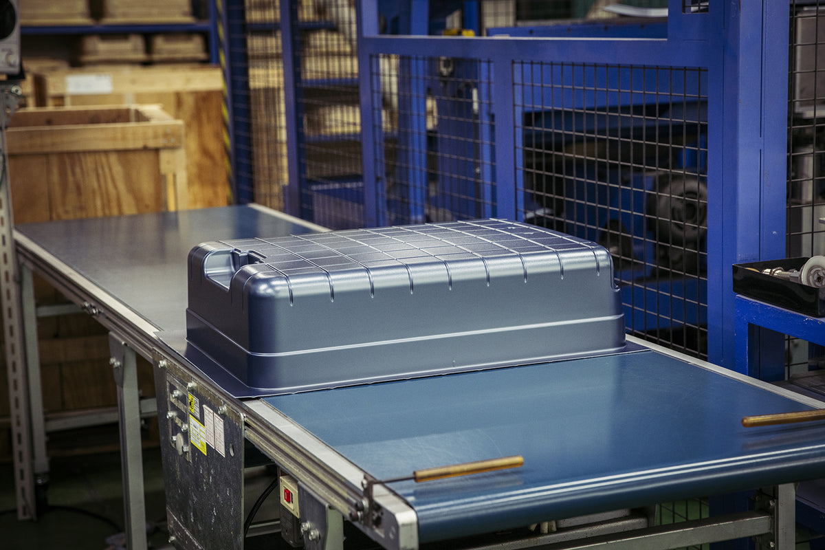 Hard-shell suitcase panel on conveyor belt during factory production process
